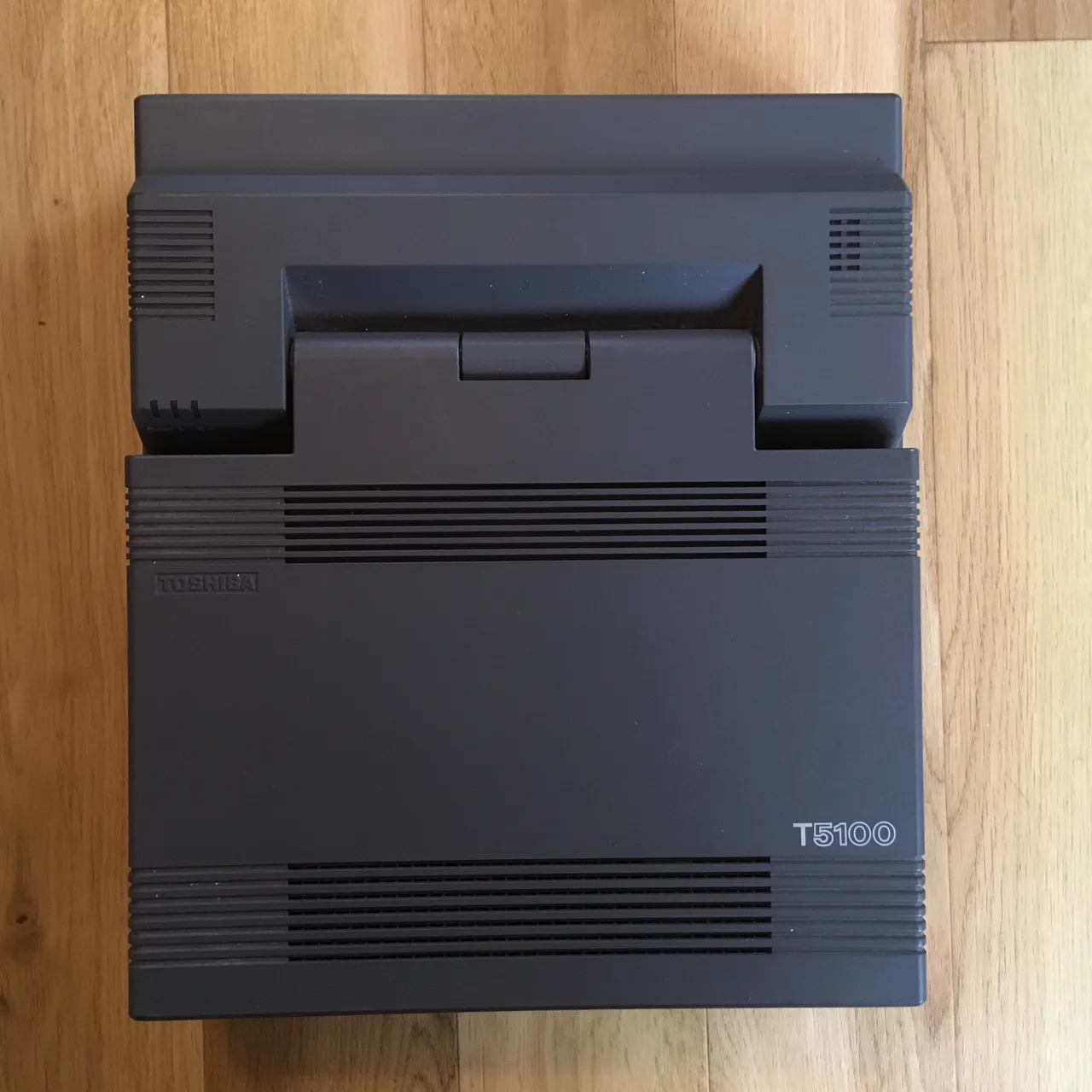 Top-down view of a Toshiba T5100, its a grey square computer with many vents
